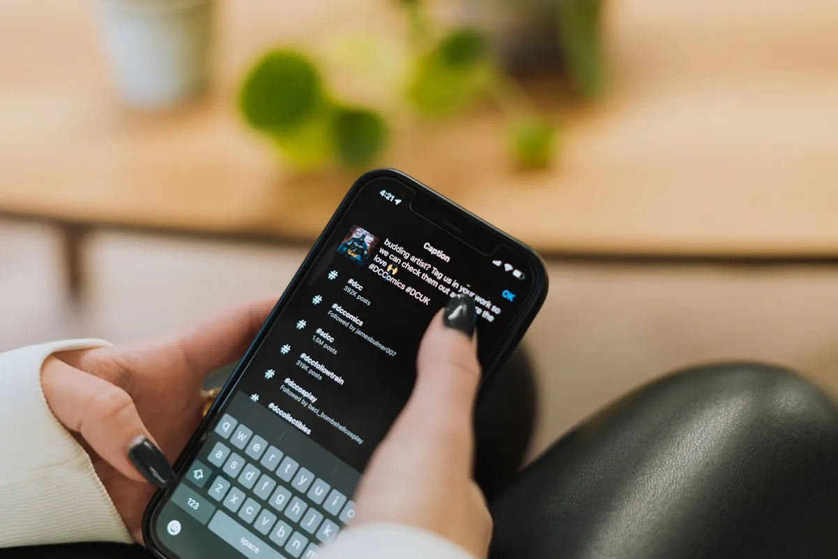 A person holding a smartphone displaying a chat-thread interface
